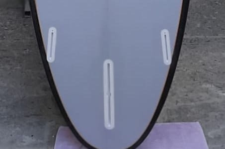 Fundo de uma prancha mostrando uma caixa central de longboard e duas caixas laterais Future